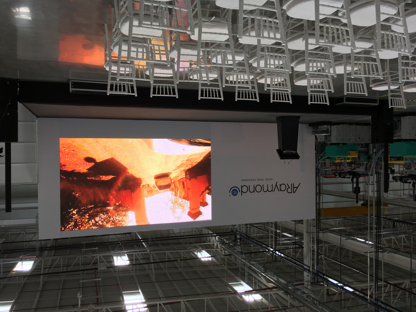 Corporate stage presentation with screen display, ARaymond manufacturing event